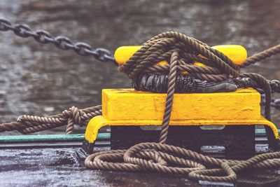 Close-up of rope tied to bollard at harbor