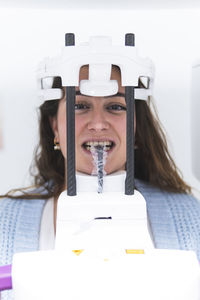 Woman getting dental x-ray of teeth through equipment at clinic