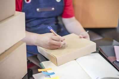 Midsection of man reading book on table