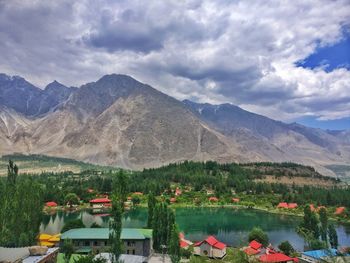 Scenic view of lake and mountains against cloudy sky 