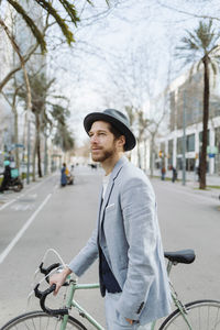 Young man riding bicycle in city
