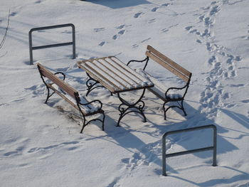High angle view of empty chairs on snow covered field