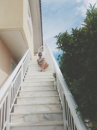 Low angle view of woman on staircase against sky
