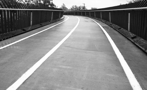 Empty road leading towards bridge