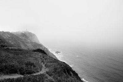 Scenic view of sea and mountains against sky