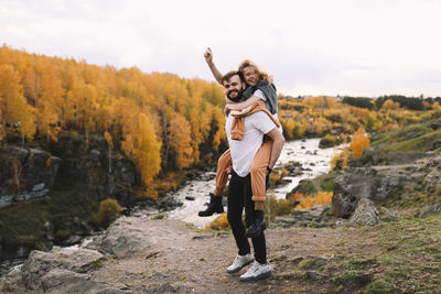 Happy people in love are travel hike in nature in the autumn forest. romantic trip to countryside