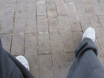 Low section of person standing on tiled floor