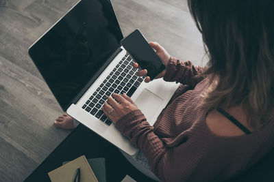 High angle view of woman using laptop on table at home