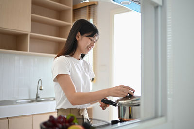 Portrait of young woman using mobile phone while standing in bathroom