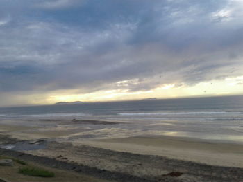 Scenic view of beach against sky during sunset