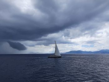 Sailboat sailing on sea against sky