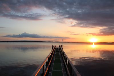 Pier on sea at sunset