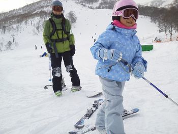 Woman and girl on snow covered landscape