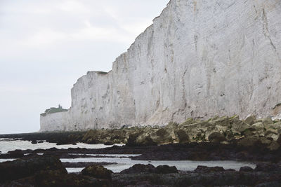 Rock formations by sea against sky