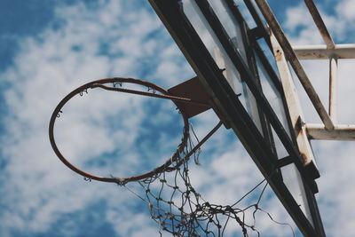 Low angle view of abandoned basketball hoop against sky