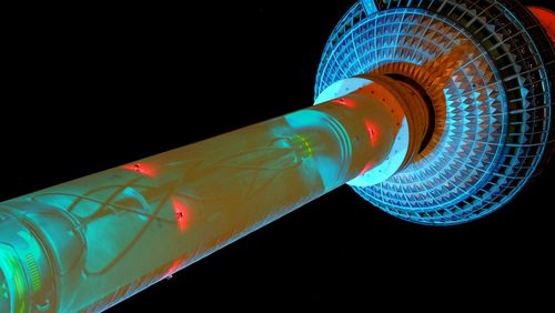 Low angle view of illuminated lights against black background