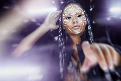 Portrait of young woman with beads on face