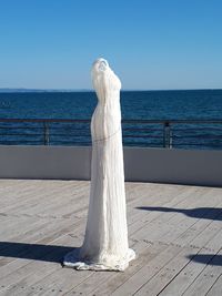 White railing against sea against clear sky