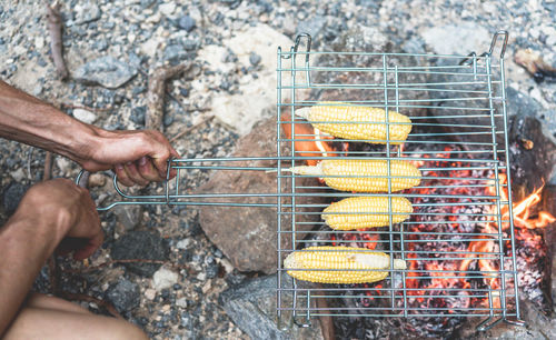 Midsection of man preparing food on barbecue grill