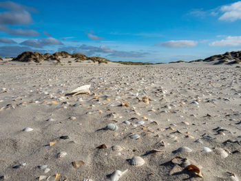 Surface level of sandy beach against sky