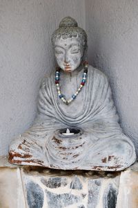Statue of buddha against wall