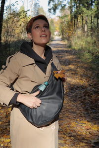 Portrait of smiling young woman standing on land