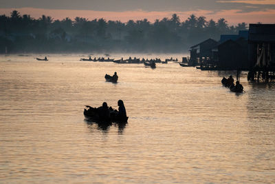 Silhouette people in a river