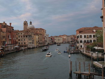 Boats in canal amidst buildings in city