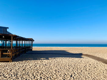 Scenic view of beach against clear blue sky