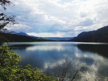 Scenic view of lake by mountains against sky