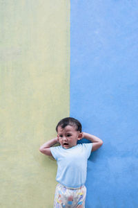 Cute girl standing against wall