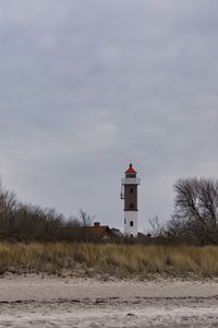 Lighthouse by sea against sky