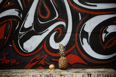 Onion and pineapple against graffiti wall