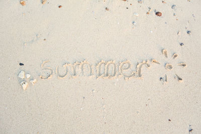 Word "summer" written on sand