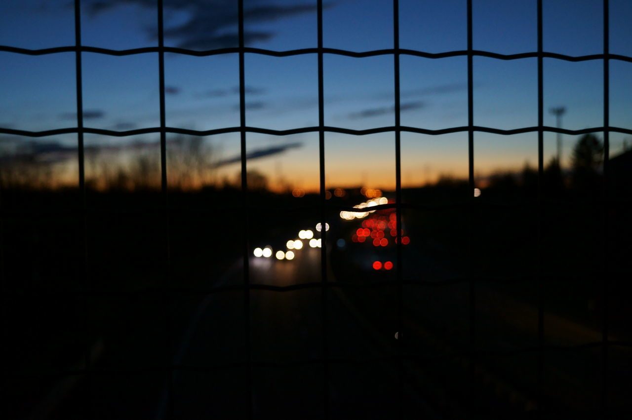 VIEW OF ILLUMINATED ROAD AGAINST SKY