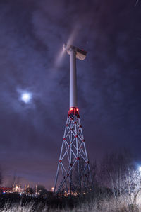 Low angle view of wind turbine against cloudy sky at night