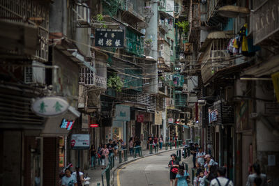 People walking on street amidst buildings in city