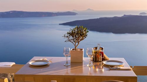 High angle view of coffee and drink on table against sky during sunset