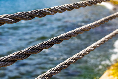 Close up steel rope at beach and sea. grey cord.