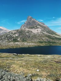 Scenic view of mountains against blue sky and lake in a wild environment 