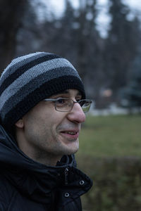 Close-up of smiling man wearing knit hat and eyeglasses