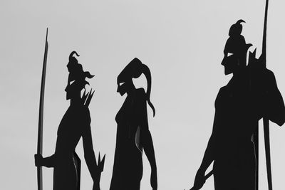 Low angle view of silhouette statue against clear sky