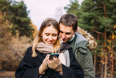 Young woman using mobile phone in winter