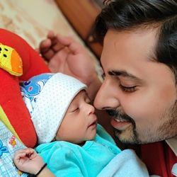 Close-up of smiling father with daughter on bed at home