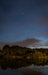 Scenic view of lake against starry sky at night