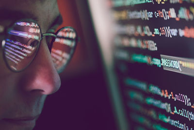 Side view of programmer looking at binary code in office