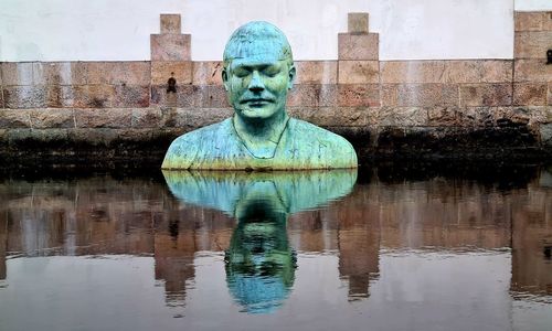 Digital composite image of statue against water