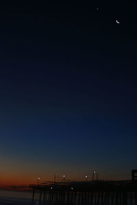 Low angle view of silhouette buildings against clear sky at night