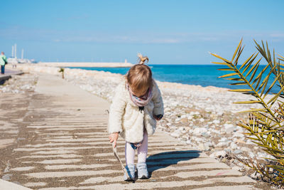 Rear view of woman on beach against sky