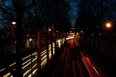 Illuminated light trails on railroad tracks at night